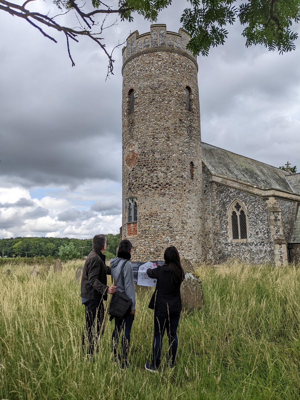 a group of walkers with a map looking at Haveringland church